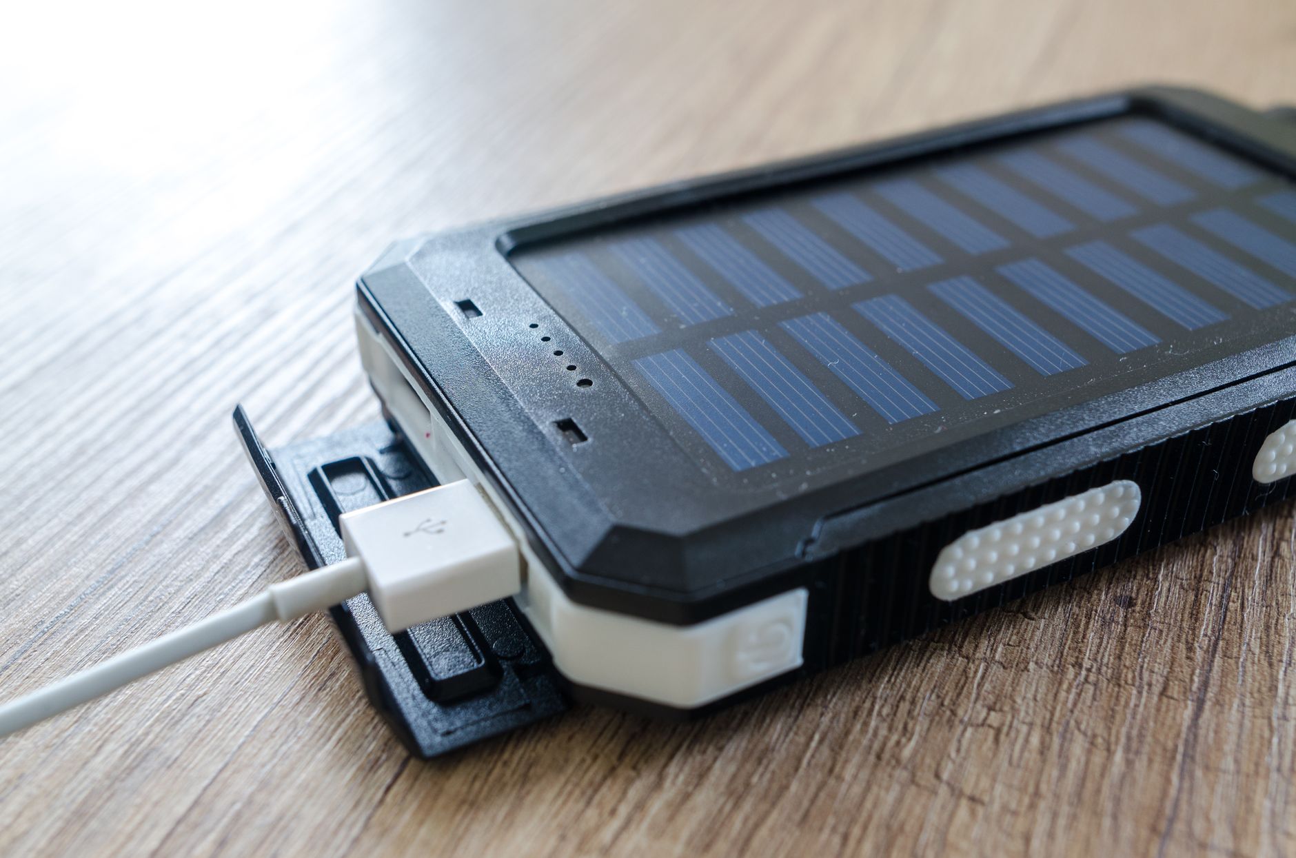 Compact solar charger folded on a backpack during a mountain trek